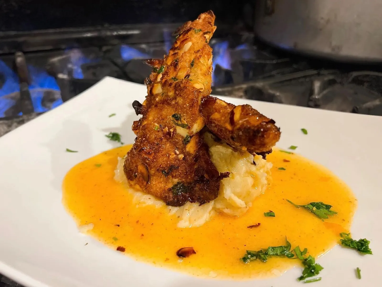 Almond-crusted salmon plated over the range's open flame